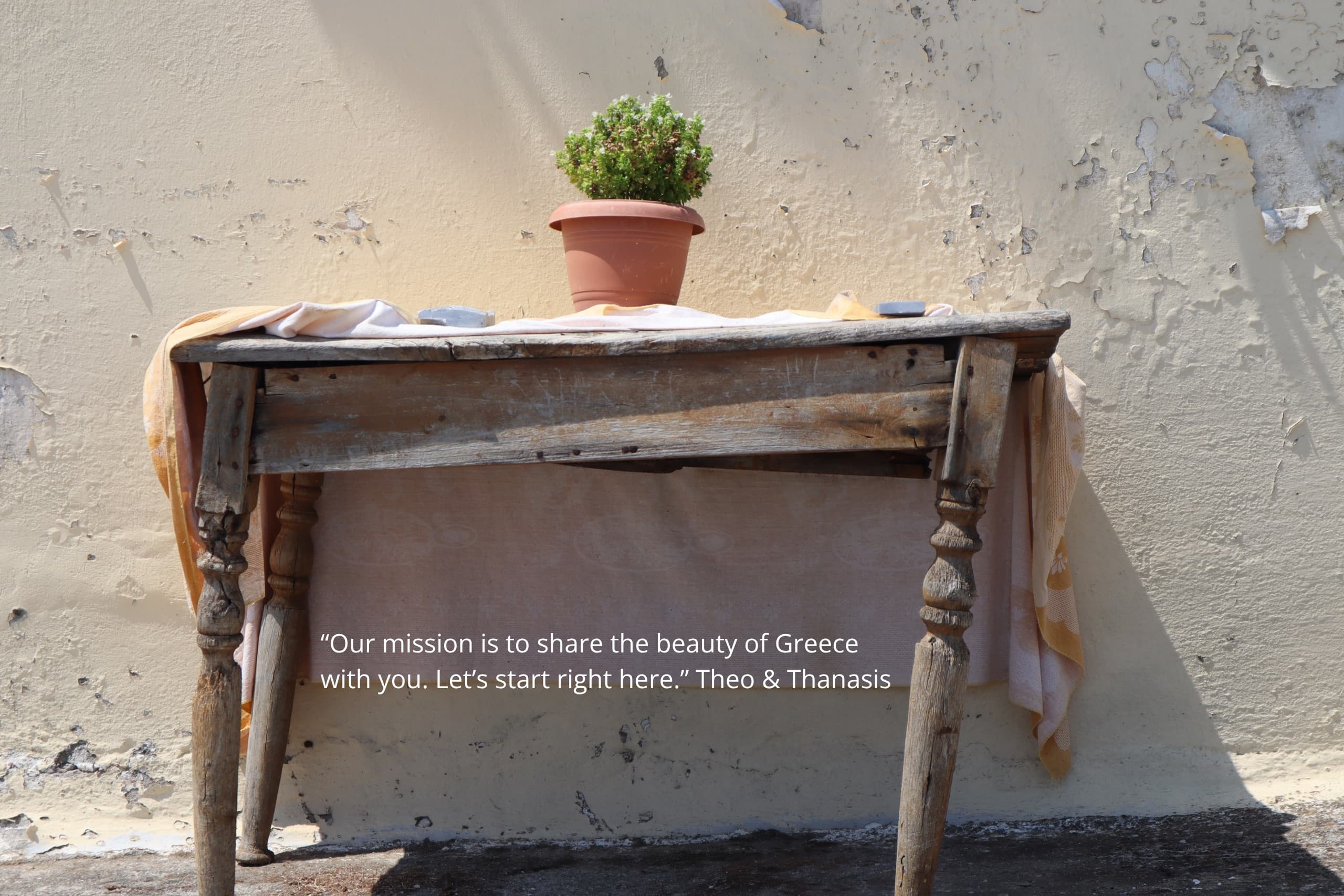 “Our mission is to share the beauty of Greece with you. Let’s start right here.” — a rustic table and potted plant in the Greek sun, Monobrow Holidays Greece